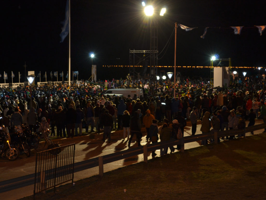 Multitud reunida en un acto, frente a monumento, de noche